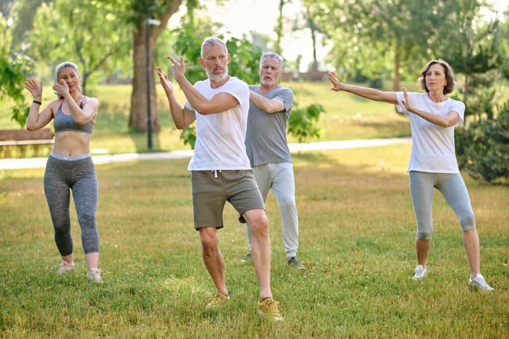 a group of people practicing qigong in a park